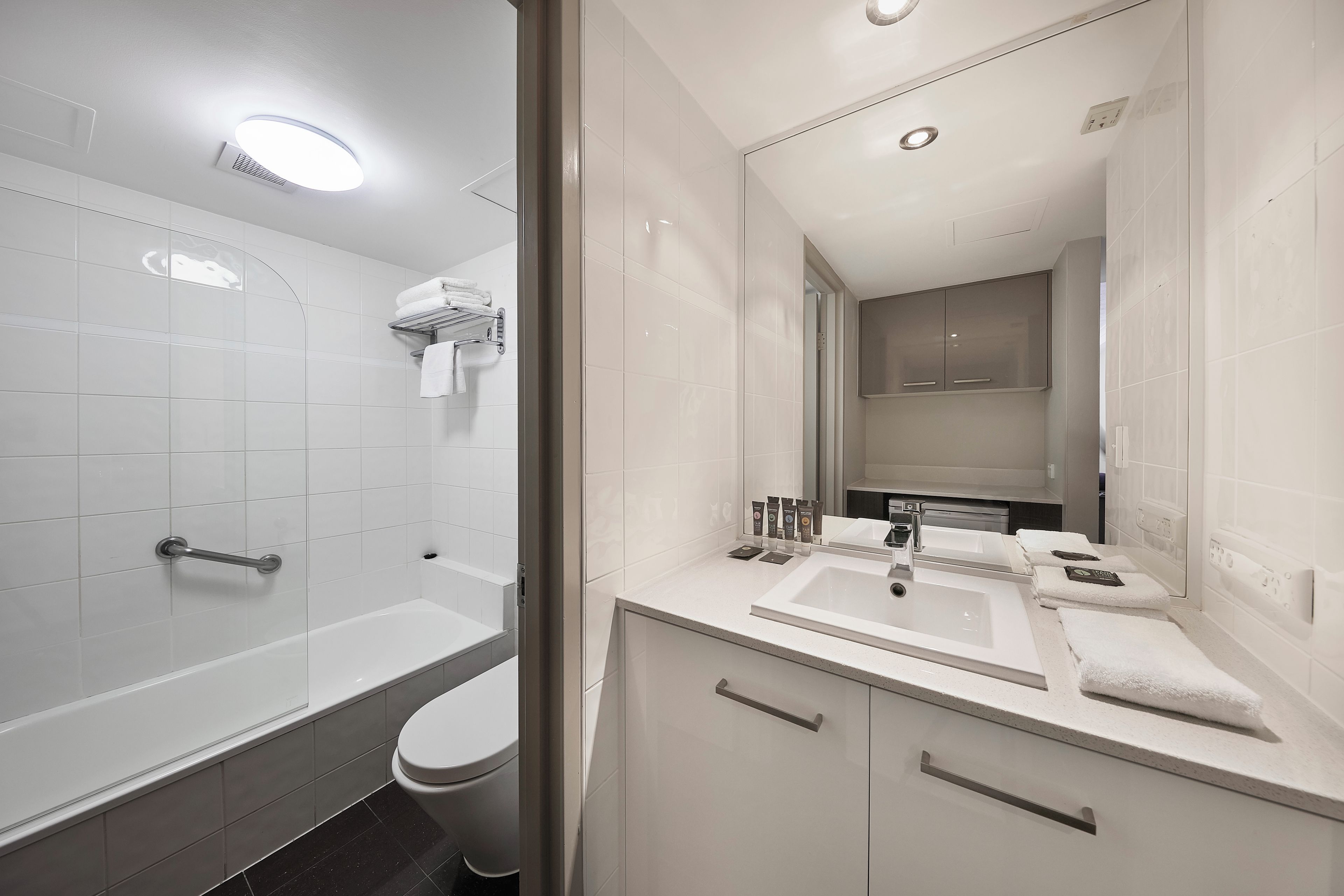 A modern bathroom with a bathtub, toilet, and sink.