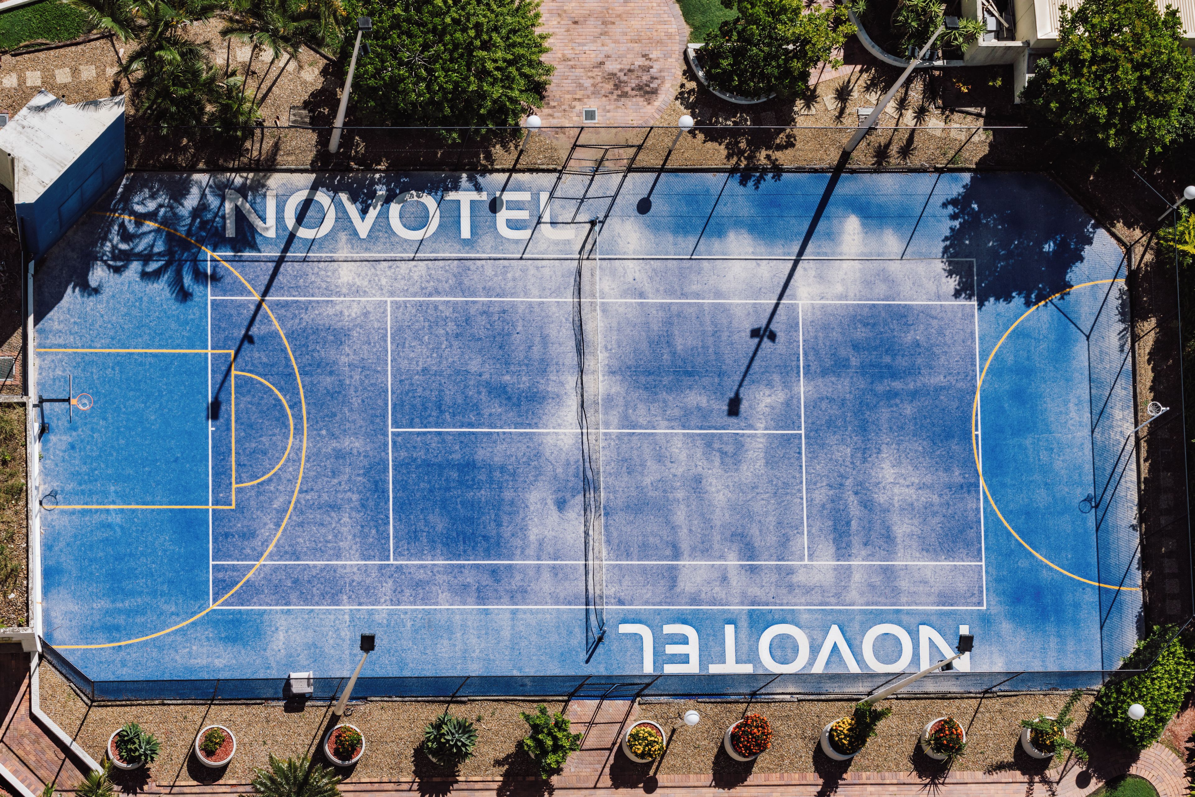 Vista aérea de una cancha de baloncesto con la palabra 'NOVOTEL' pintada en ella.