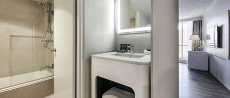 A modern bathroom with a shower, sink, and a mirror.
