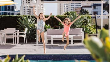 Relax by the pool surrounded by lush greenery and a city view.