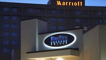 Stunning hotel exterior with a modern design, marquee sign, and beautifully maintained garden.