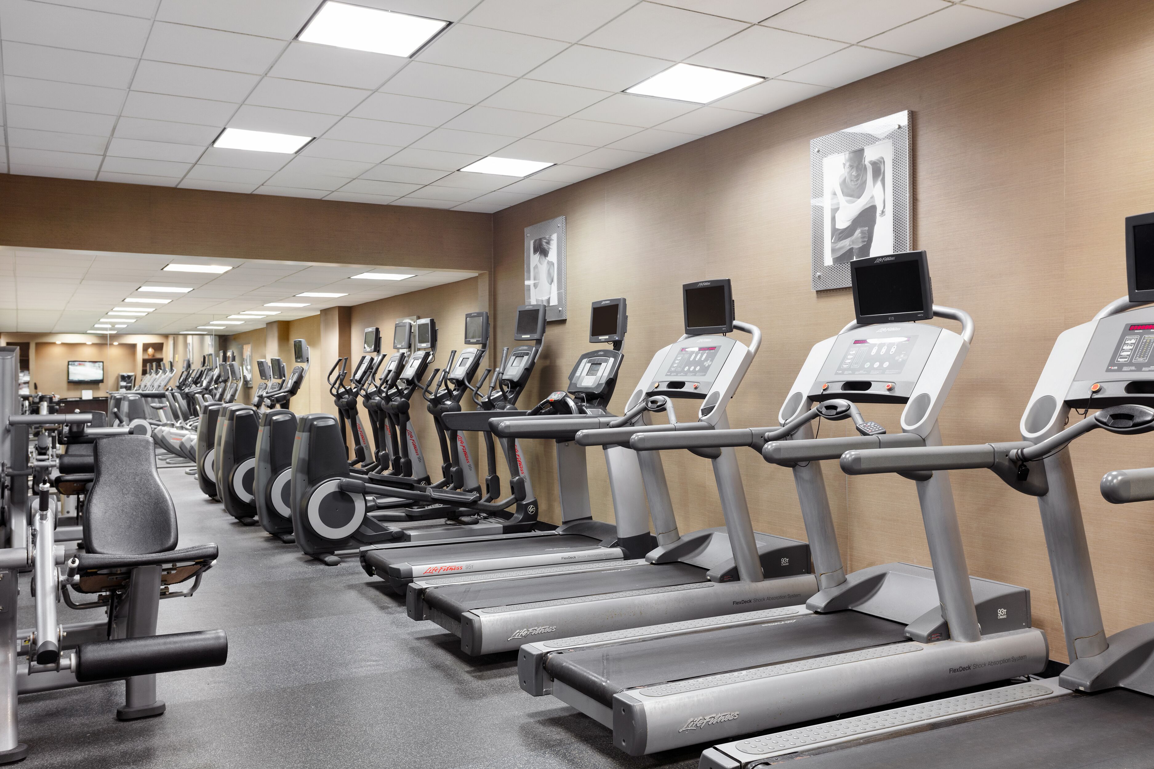 Ein Fitnessstudio mit mehreren Laufbändern und Trainingsgeräten.