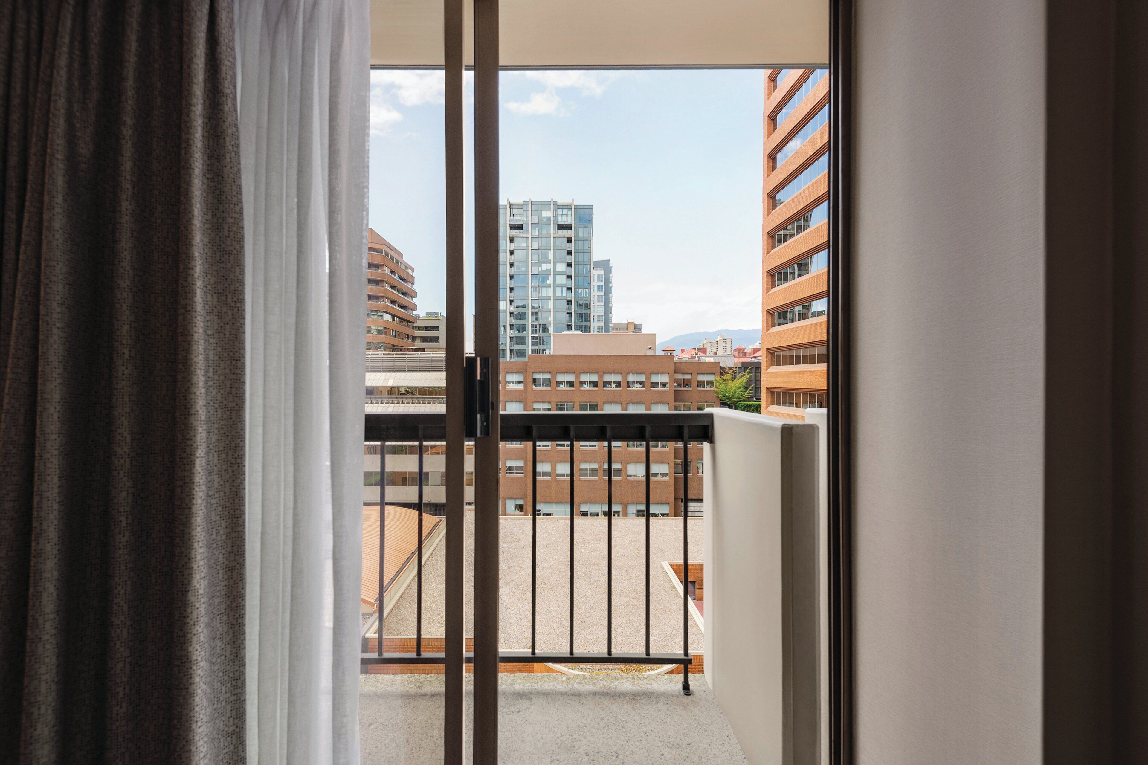 A balcony with a view of high-rise buildings and a clear sky.