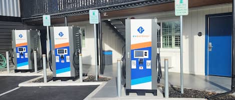 A row of EVGATEWAY electric vehicle charging stations in a parking lot.