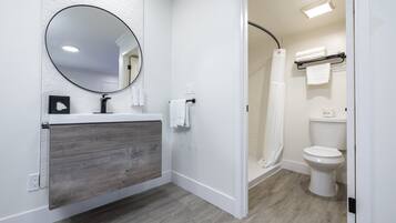 Tina con regadera, amenidades de baño de diseñador, toallas