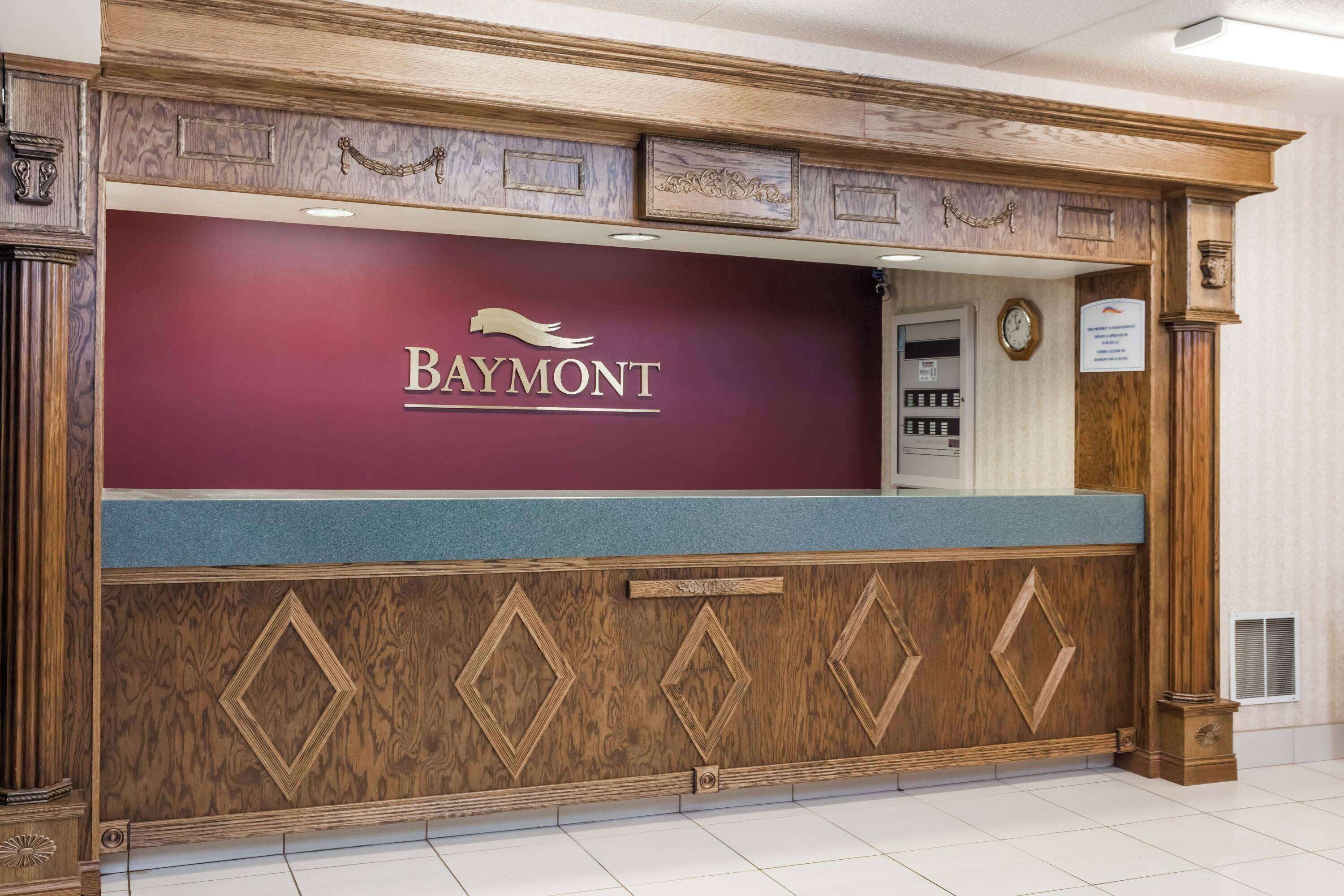 A reception desk with a maroon backdrop and the Baymont logo.