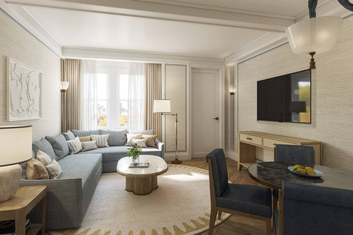 A modern living room with a sectional sofa, a round coffee table, and a dining area with a small table and chairs.