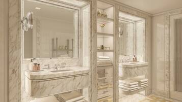 A luxurious bathroom with marble countertops, dual sinks, and a large mirror.
