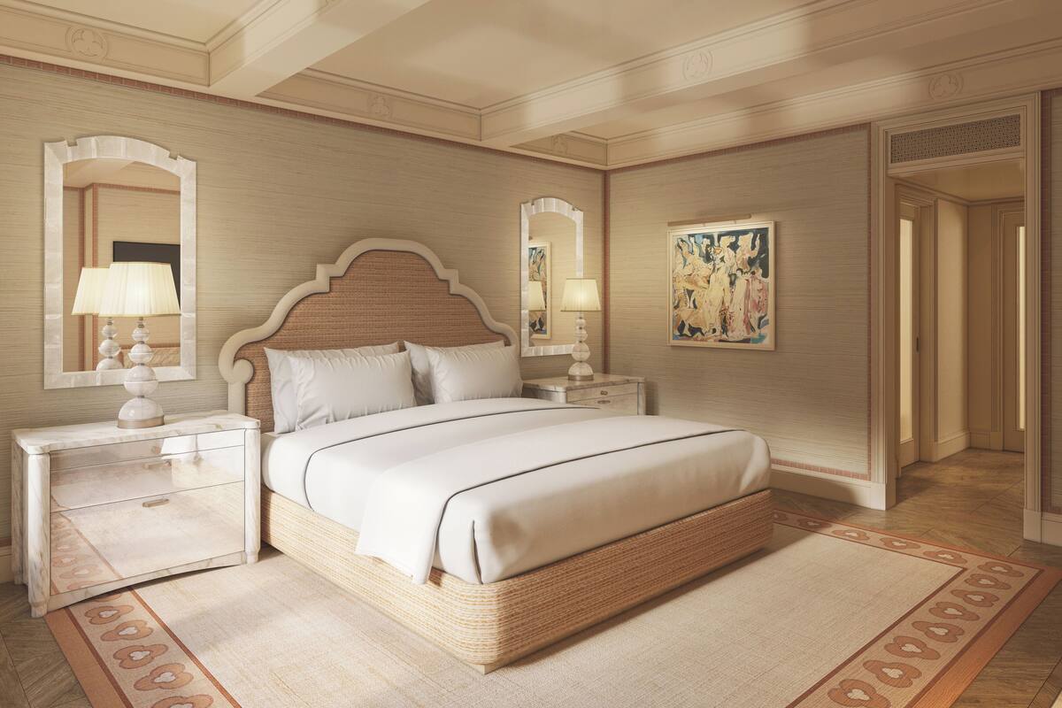 A bedroom with a large bed, two bedside tables with lamps, a mirror, and a painting on the wall.