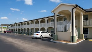 A motel with a row of rooms, a covered parking area, and a staircase leading to the upper floor. - Days Inn by Wyndham Bradenton I-75 (Bradenton)