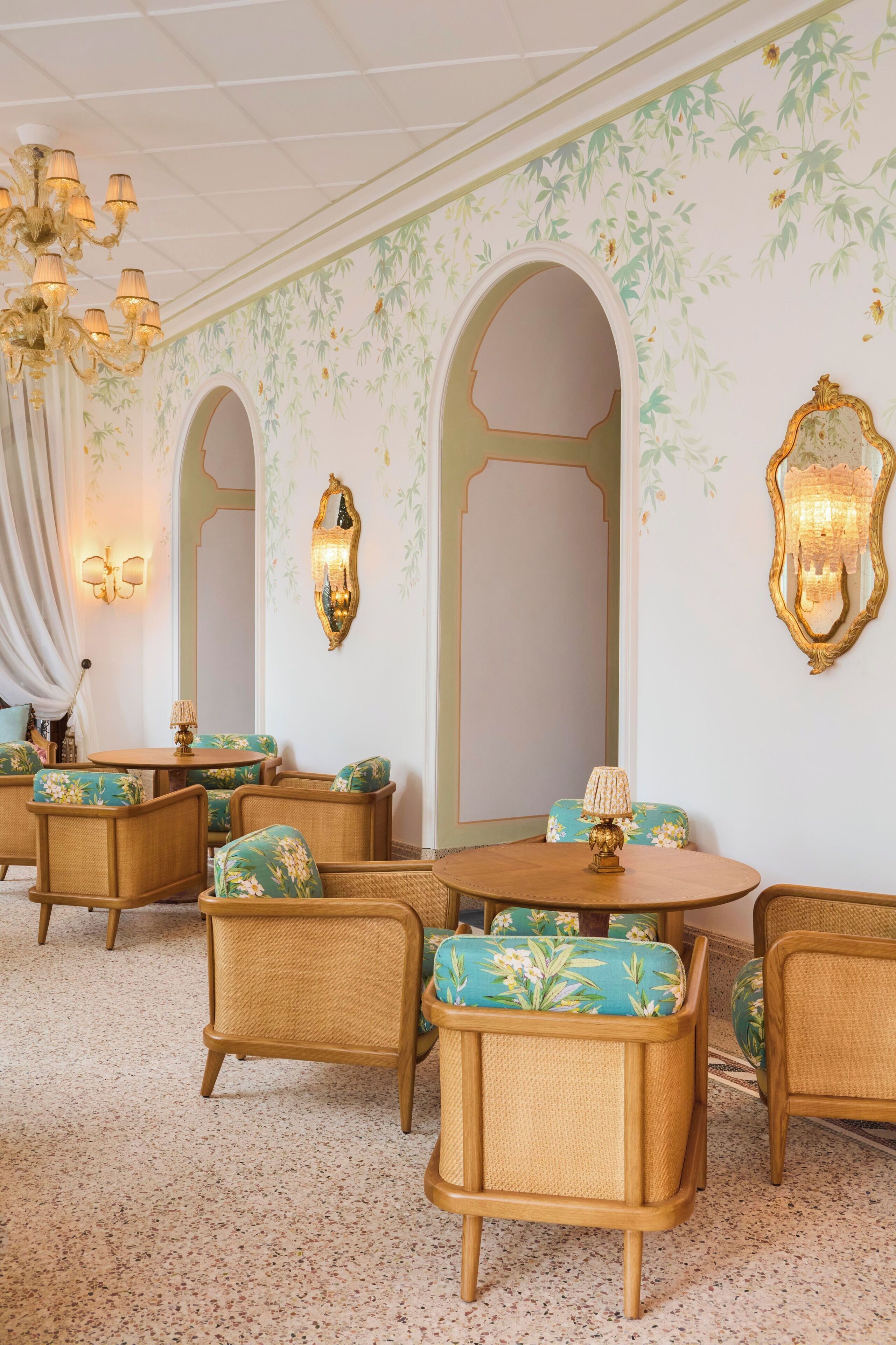 Una habitación de diseño clásico, con candelabro, papel tapiz floral y muebles tradicionales.