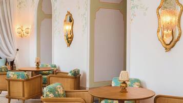 Una habitación de diseño clásico, con candelabro, papel tapiz floral y muebles tradicionales.