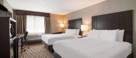 A hotel room with two beds, a desk, a chair, and a TV.