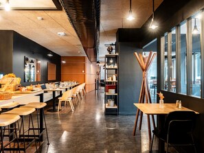 A modern dining area with long communal tables, high ceilings, and large windows. - ibis Styles Lyon Villeurbanne Parc de la Tête d'Or (Villeurbanne)