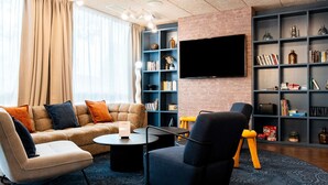 A modern living room with a sofa, armchairs, a coffee table, and a bookshelf.