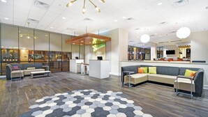 A modern lobby with a reception desk, seating area, and a hexagonal patterned floor. - Holiday Inn Downtown Memphis by IHG (Memphis)