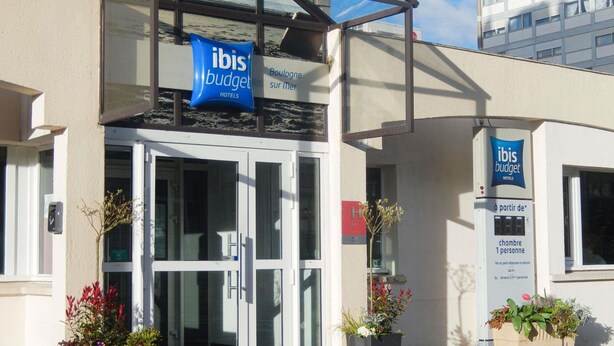 A hotel entrance with glass doors, a sign for "ibis budget hotels," and a digital display for room availability. - ibis budget Boulogne-sur-Mer Centre les Ports (Boulogne-sur-Mer)