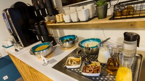 A breakfast buffet setup with various food items and condiments. - ibis budget Boulogne-sur-Mer Centre les Ports (Boulogne-sur-Mer)
