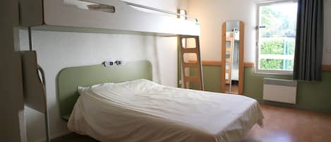 Ett enkelrum med en våningssäng, ett fönster med gardiner, ett element och en trästol.