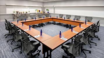 A conference room with a long table, chairs, and a whiteboard.
