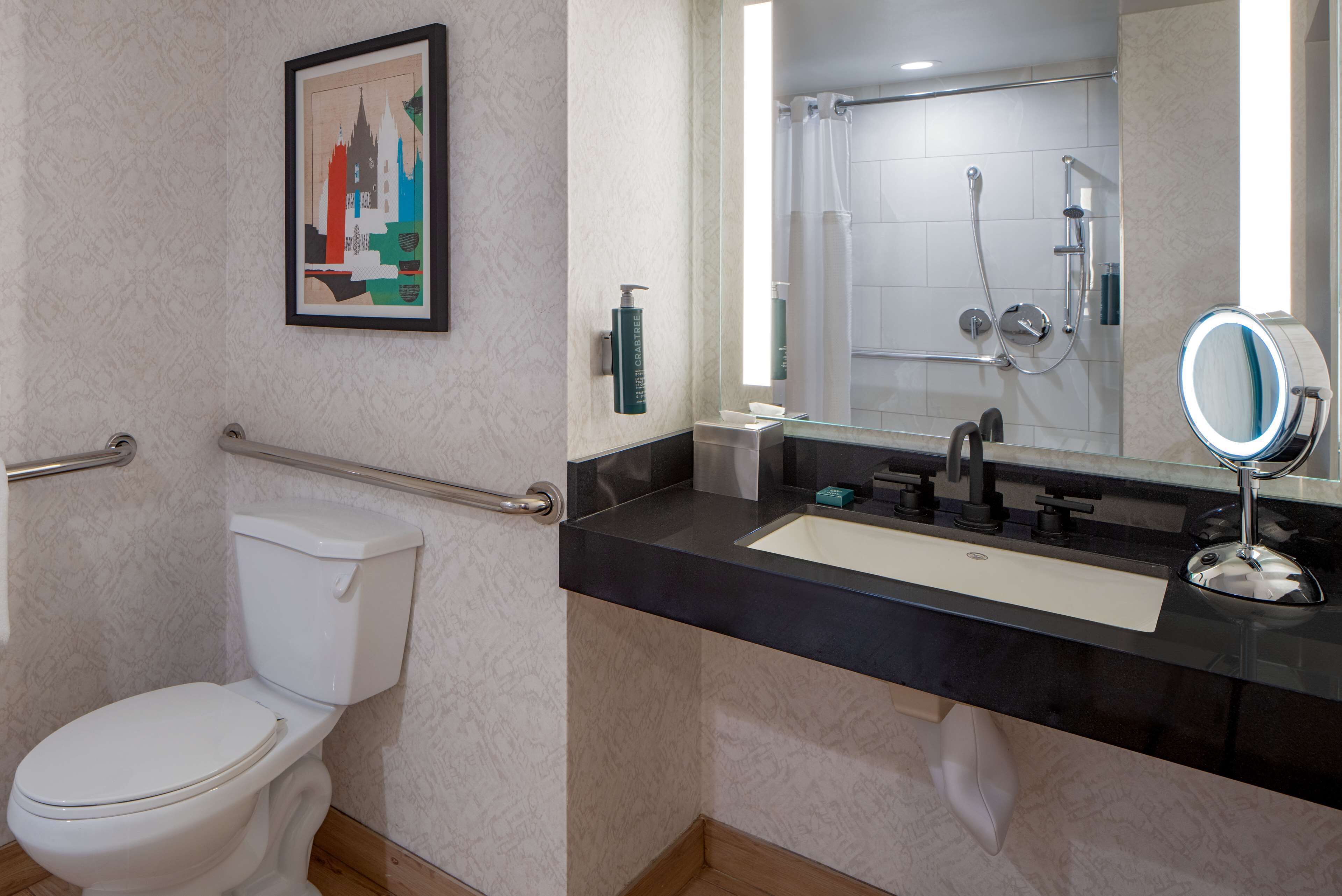 A bathroom with a toilet, sink, and shower.