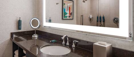 Un baño moderno con un espejo grande, un lavabo y una zona de ducha.