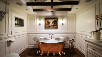 A bathroom with a freestanding bathtub, a toilet, and a sink.