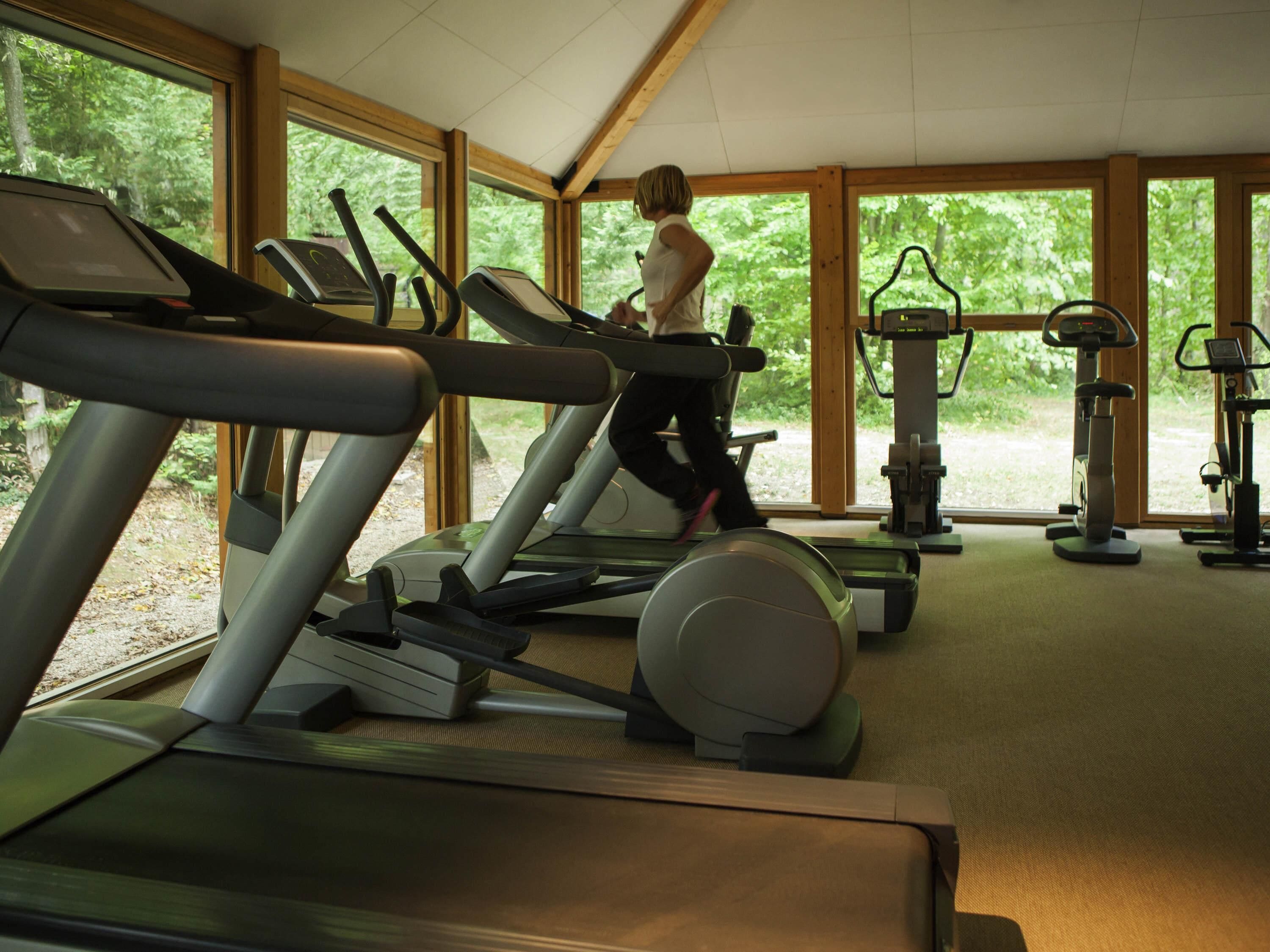 A gym with treadmills, an elliptical, and a stationary bike.