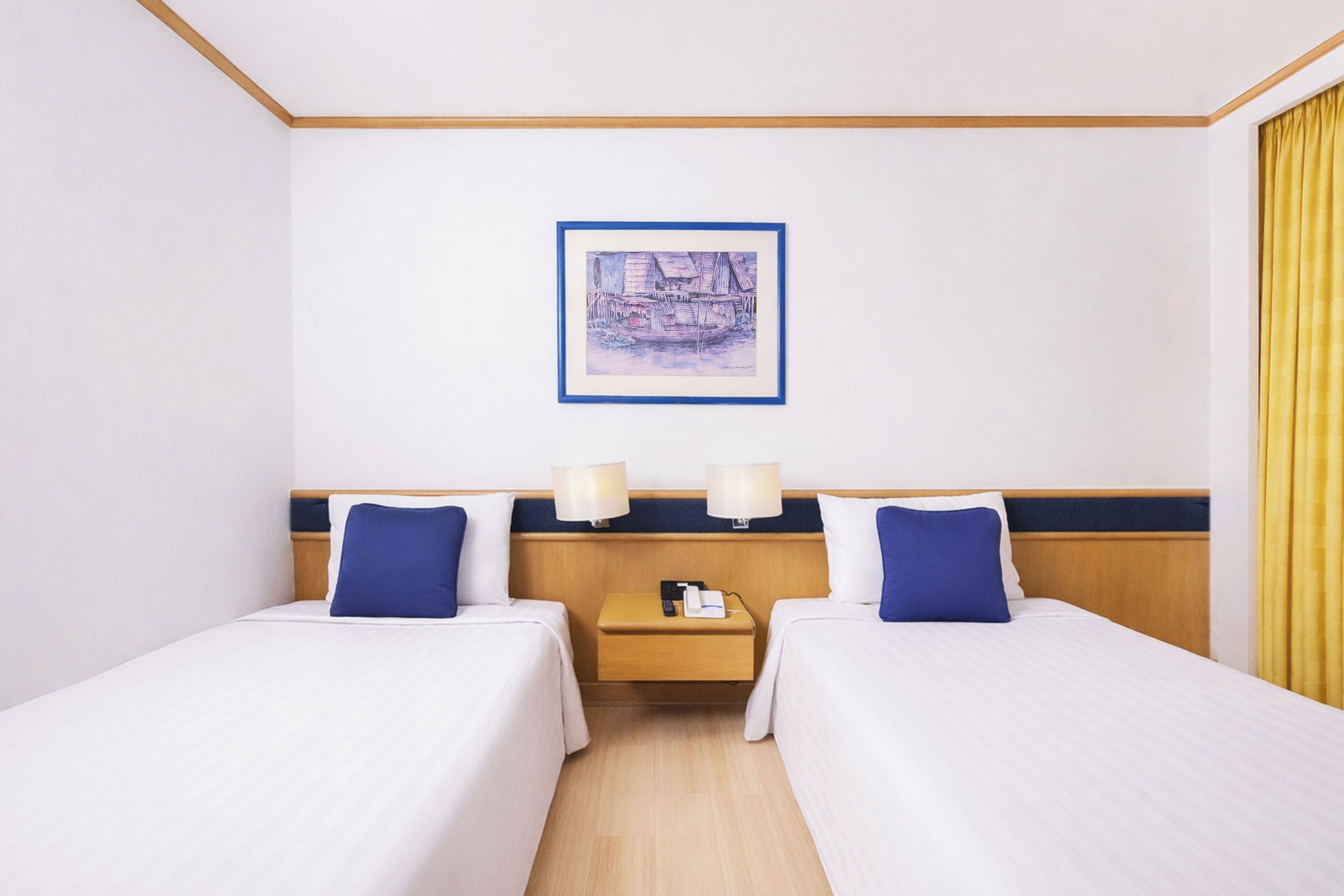 A hotel room with two beds, a nightstand, a framed picture on the wall, and a window with curtains.