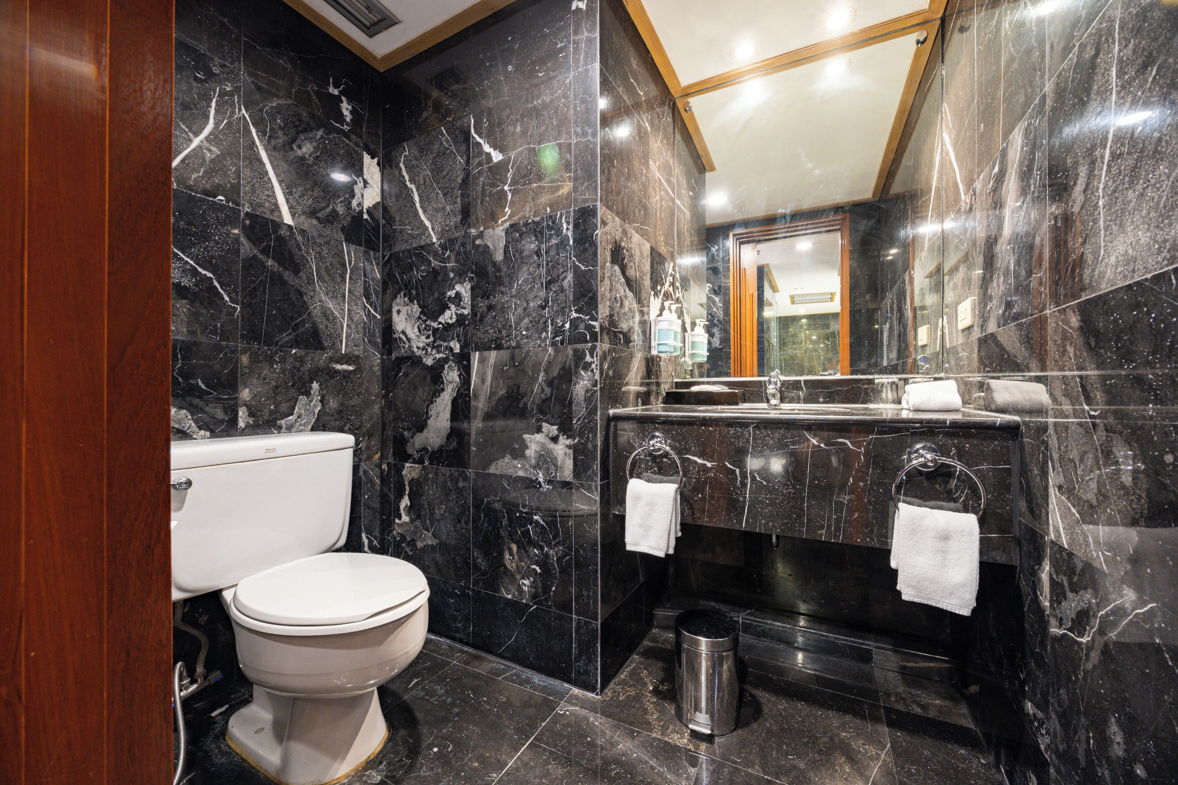 Un baño con inodoro, lavamanos y espejo.