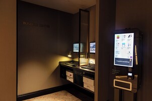 Ein Geschäftszentrum mit einem Computer, einer Schreibtischlampe und einem digitalen Kiosk, der verschiedene Dienstleistungen anzeigt.