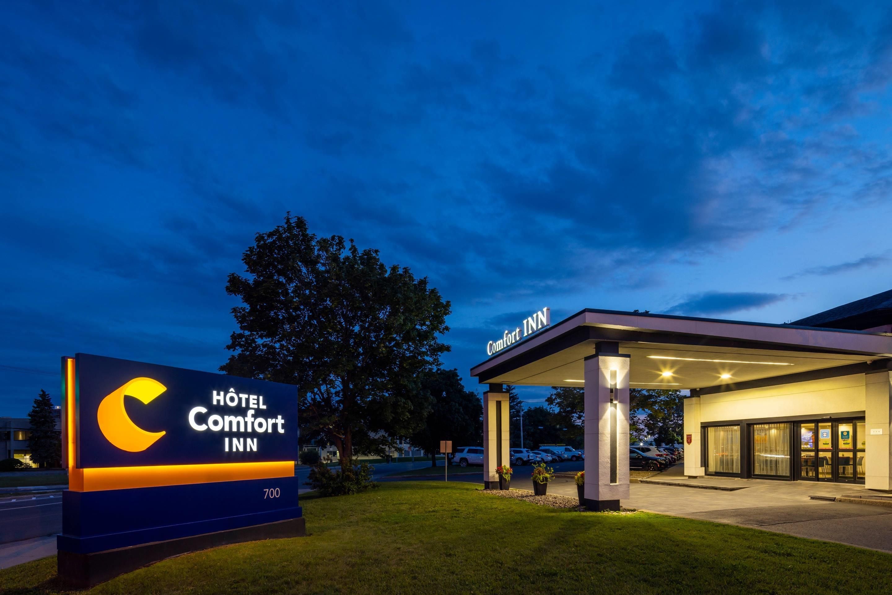 Señal de Hotel Comfort Inn con entrada a un edificio moderno.