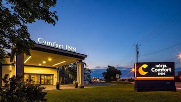 Un Hotel Comfort Inn con un letrero claro, un acceso cubierto y una fachada bien iluminada.