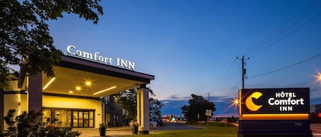 A Hotel Comfort Inn with a clear sign, a covered entrance, and a well-lit facade.