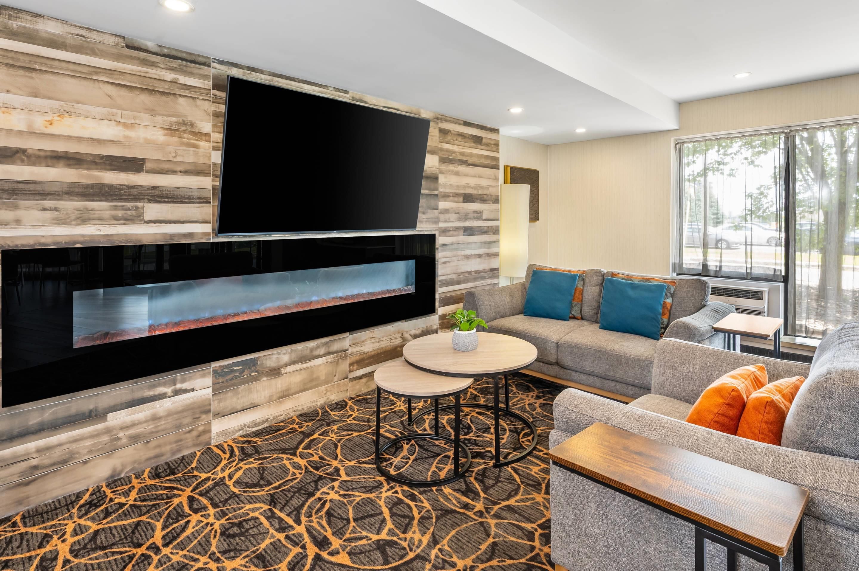 A modern living room with a fireplace, a flat-screen TV, a sofa, and a coffee table.