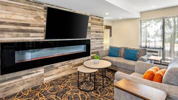 A modern living room with a fireplace, a flat-screen TV, a sofa, and a coffee table.