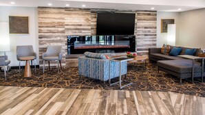 A modern living room with a fireplace, comfortable seating, and a flat-screen TV. - Comfort Inn Montréal A éroport (Pointe Claire)