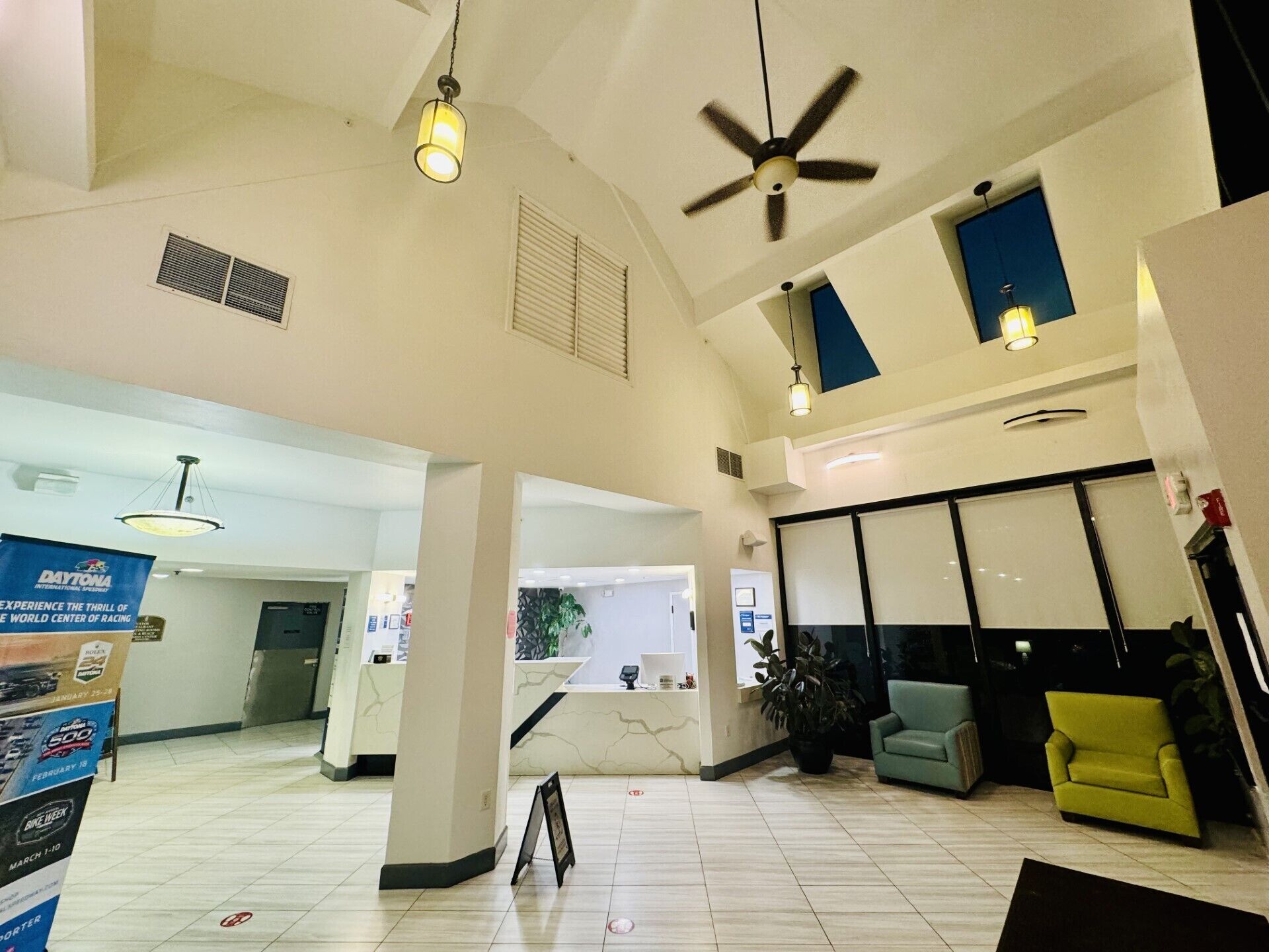 A spacious lobby with a reception desk, seating area, and a large window.