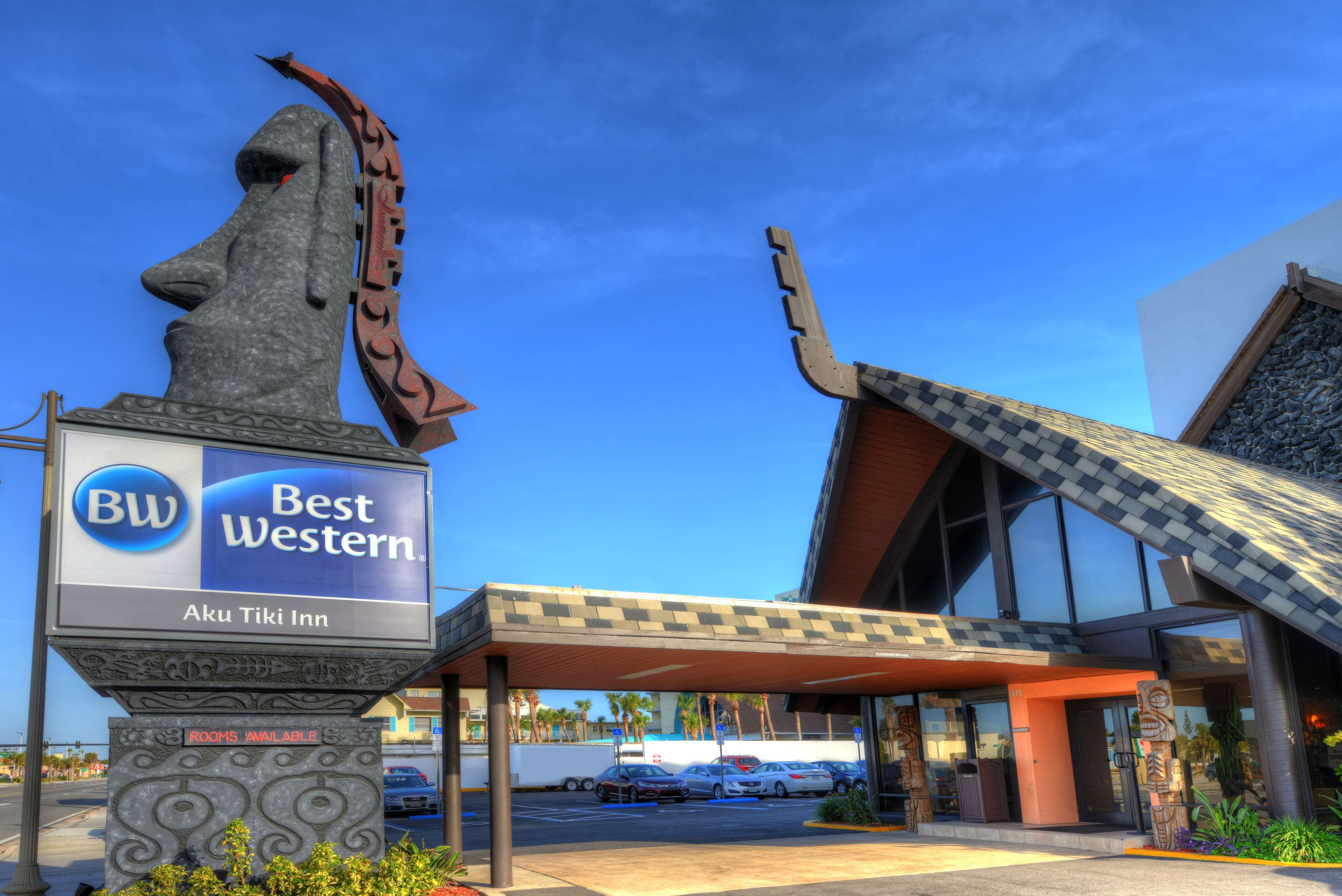Een Best Western hotel met een opvallende stenen sculptuur, een overdekte parkeerplaats en een moderne gevel.