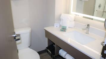 Een badkamer met een wit toilet, een wastafel met spiegel en een handdoekhouder.