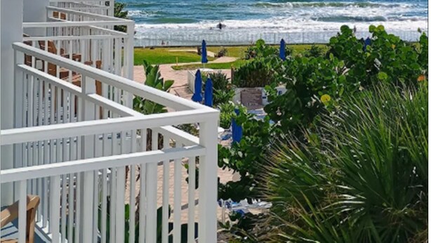 A balcony with a view of the ocean and beach.