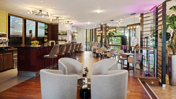 Een modern interieur met een bar, zitplaatsen en een groot raam.