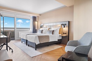 Ein modernes Hotelzimmer mit einem großen Bett, einem Schreibtisch und einem Stuhl.