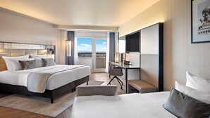 Een moderne hotelkamer met een groot bed, een bureau en uitzicht over de stad.