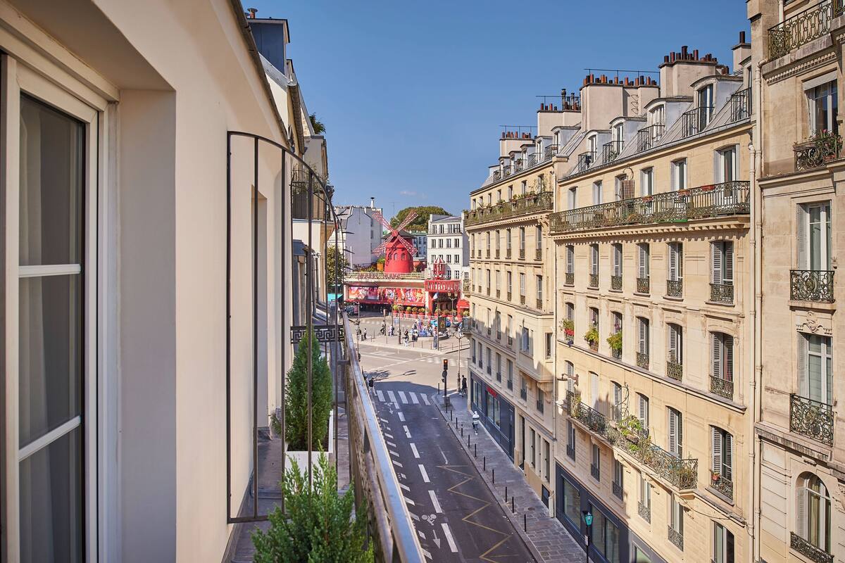 Una vista di una strada con edifici, un mulino a vento e un cartello rosso.
