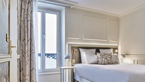 A hotel room with a large bed, a bedside table, and a window with curtains. - Posy Hotel by Happyculture (Paris)