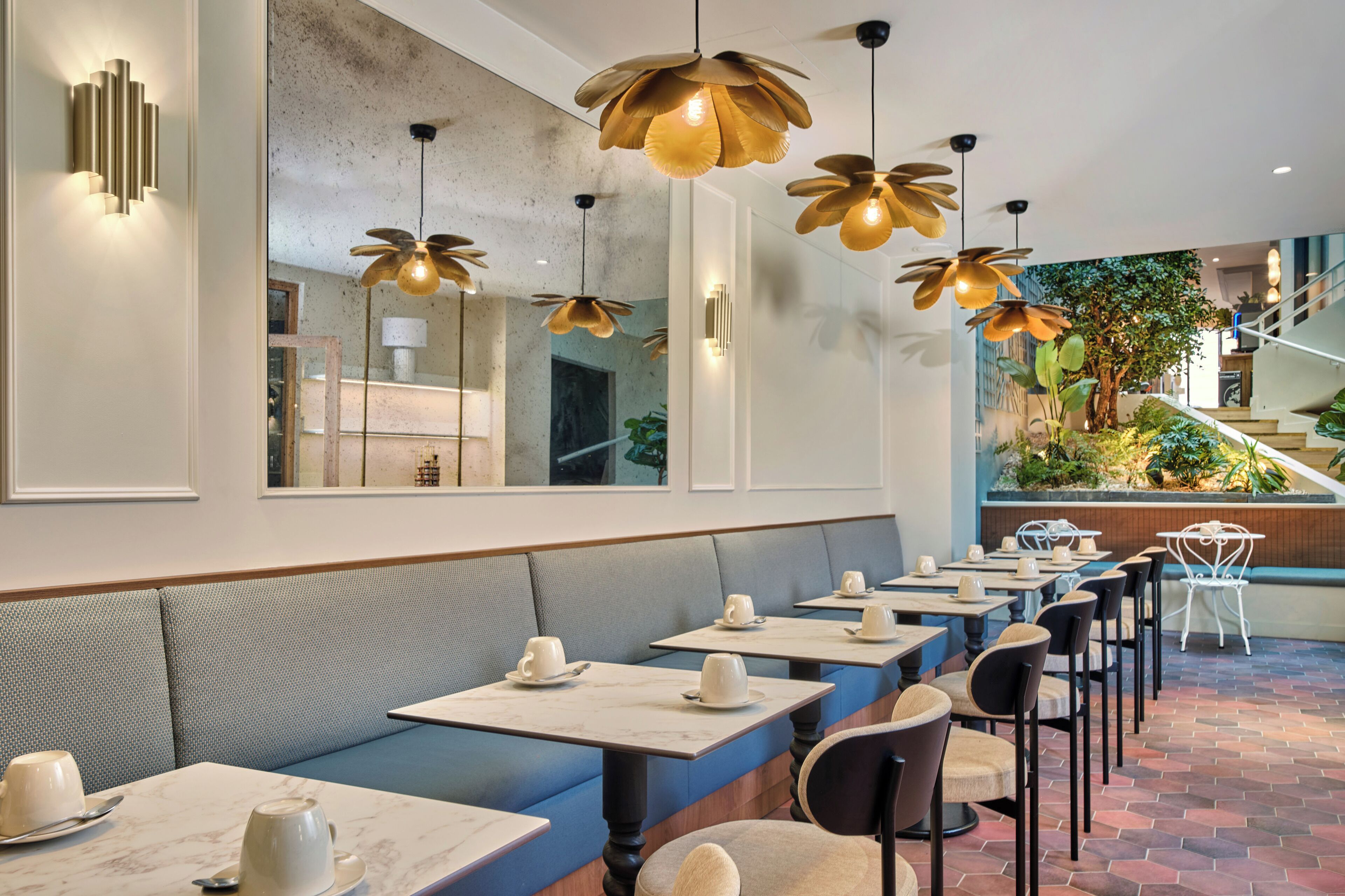 Un restaurante con cabinas, mesas y lámparas colgantes con forma de flor.