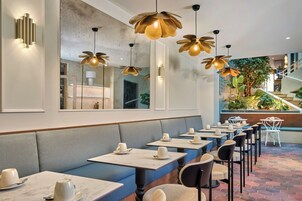 A restaurant with booths, tables, and hanging flower-shaped lights.