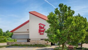 A Red Roof Inn with a stone facade, a red roof, and a parking lot. - Red Roof Inn Erie – I-90 (Erie)