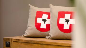 Two pillows with a red and white cross design on a wooden surface.